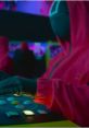 Male announcer in Squid Game - The Challenge wearing a red hoodie, focused on game controls with vibrant arcade background.