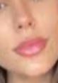 Close-up of a woman's face showcasing soft, natural makeup and prominent lips, highlighting beauty and confidence.