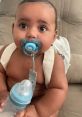 Cute baby with a pacifier and bottle, sitting on a couch, showcasing innocence and charm—perfect for family horror themes.