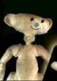 Cute plush toy resembling the Bear from Bear Alpha, showcasing a smiling face and distinctive features against a dark background.