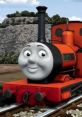 Cheerful Rheneas, voiced by Ben Small, on the railway, showcasing his iconic orange and black design. Kids' favorite character!