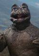 Minilla, a young Godzilla monster, smiles in a rocky landscape, showcasing its unique texture and playful demeanor.