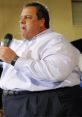 Chris Christie speaking at an event, engaging the audience passionately with a microphone in hand.