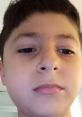 Boy with short brown hair and serious expression, capturing a close-up moment, representing youthful curiosity.
