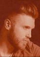 Profile portrait of Brandon Ray with a stylish haircut and beard, set in a warm sepia tone.
