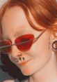 Red-haired individual sporting trendy red sunglasses and unique facial piercings, showcasing contemporary style and attitude.