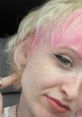 Young person with pink and blonde hair, showcasing vibrant hair color and natural makeup style, promoting self-expression.