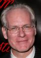 Tim Gunn at an event, showcasing his signature style and charisma, embodying fashion expertise and mentorship.