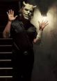 The Grabber, a sinister figure, stands against a dimly lit wall, showcasing a menacing mask and eerie presence.