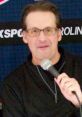 John Forslund, play-by-play announcer for the Carolina Hurricanes, speaking into a microphone at an event.