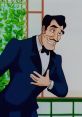Gaston Adams Smith in a tuxedo, smiling and gesturing charmingly against a lush green background.