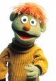 Farley, the lovable Muppet from Sesame Street, features green fur and orange hair, wearing a cozy yellow sweater.