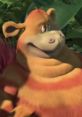 Tommy from Horton Hears A Who (2008) smiling, with bright orange and yellow fur, surrounded by lush greenery.