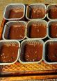 Chocolate batter in metal baking cups, ready for the oven, ideal for creating a batch of delicious treats.