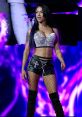 Elayna Black in sparkling crop top and leather shorts, exuding confidence on stage with vibrant purple background.