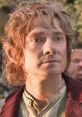 Bilbo Baggins with wavy hair, showing curiosity and determination in a lush, vibrant setting from "The Hobbit.