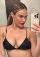 CJ Perry showcases a stylish black bikini and bold red lipstick, highlighting her striking look in this confident selfie.