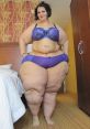 Confident woman in purple lingerie showcasing curves and body positivity in a cozy hotel room setting.
