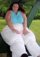 Woman in casual blue top seated outdoors, showcasing confidence and comfort in her style. Celebrating body positivity.