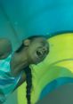 Joyful child laughing while sliding down a colorful indoor slide, showcasing excitement and fun in a playful setting.