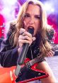 Lzzy Hale passionately performing on stage with her guitar, exuding energy and power during a live concert.