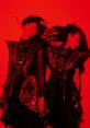 Babymetal performers in striking black and red outfits, showcasing their iconic style and energy against a vivid backdrop.