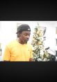 Bino from Instagram Project, surprised expression, yellow shirt, Christmas tree in background, festive home decor.