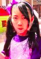 Young girl in a sparkly purple outfit with a pink bow, engaging with colorful toys in the background, showcasing fun playtime.