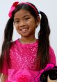 Smiling girl in a sparkly pink outfit with pigtails, embodying the fun of Emma Toys And Colors Playdate Adventures Season 1.