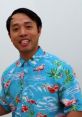 Smiling man in a vibrant Hawaiian shirt with flamingos, showcasing a cheerful and lively personality while promoting Uncle Jay.