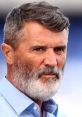 Roy Keane with a determined expression, showcasing his distinctive beard and sharp features during a press event.