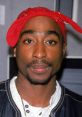 Close-up portrait of Tupac Shakur wearing a red bandana, showcasing his iconic style and intense gaze.
