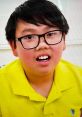A boy wearing a bright yellow shirt with glasses, displaying excitement for Vinnie Toys and Colors.