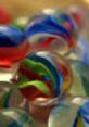 Colorful marbles swirl together in a playful display, reminiscent of the Mario And Luigi Show Marble Chaos narrative.