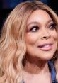 Wendy Williams smiles during a lively segment on her talk show, showcasing her signature style and engaging personality.
