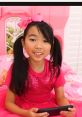 Cheerful girl in pink outfit holding a tablet, enjoying fun moments inspired by Lucy Toy and Colors Season 1-2.