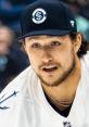 Montour focused during a game, wearing a Seattle Kraken cap and team jersey, showcasing dedication to hockey.