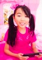Girl in pink clothes and bow, enjoying Lucy Toys and Colors on a tablet, reflecting the vibrant season 1-2 vibe.