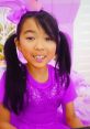 Girl in a sparkly purple outfit with a bow, smiling during a Lucy Toys and Colors playdate adventure. Fun and colorful theme!
