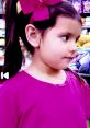 Young girl with a pink bow and shirt, exploring vibrant toys, embodying the fun and joy of Ellie Toys and Colors.