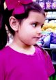 Young girl with a pink bow, wearing a purple shirt, in a colorful store setting, capturing the joy of childhood discovery.