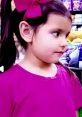 Young girl with pigtails and a pink bow, wearing a purple shirt, explores a colorful toy aisle, inspired by Toys and Colors Ellie.