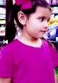 Young girl in a pink shirt with a bow, expressing curiosity in a vibrant toy store setting. Toys and colors season theme.