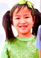 Girl in a sparkling green outfit and bow, smiling joyfully, embodies fun colors and playful energy from Jannie Toys & Colors.