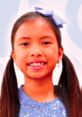 Smiling girl with pigtails and a blue bow, showcasing the fun and creativity of Wendy Toys And Colors.