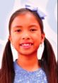 Smiling girl with pigtails wearing a blue sparkly top, promoting Wendy Toys And Colors 4 with a playful expression.