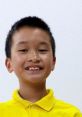 Smiling boy in a bright yellow shirt, embodying the playful spirit of Andrew Toys And Colors. Perfect for fun children's content.