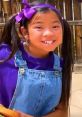 Cheerful girl in a purple shirt and overalls, showcasing the fun essence of Toys And Colors: Santa’s Little Genies.