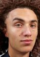 Close-up portrait of a person with curly hair and striking green eyes, representing Kwebblekop's unique style and persona.