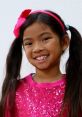 Smiling girl in a sparkly pink outfit with pigtails, showcasing vibrant style inspired by Toys & Colors Emma Nicktoons.